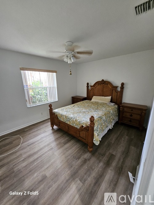 A bedroom with a bed, dresser, and window.