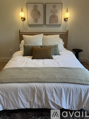 A bed with a white comforter and two pillows is in the image.