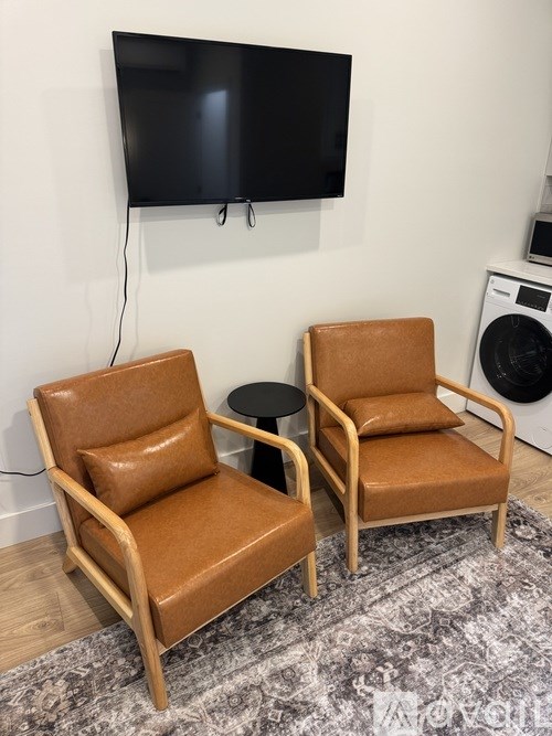 Two brown chairs are placed in front of a television.