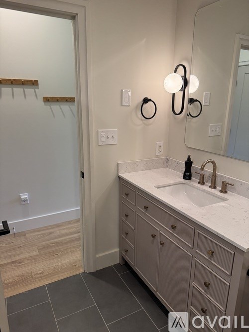 A bathroom with a sink, mirror, and light fixtures.