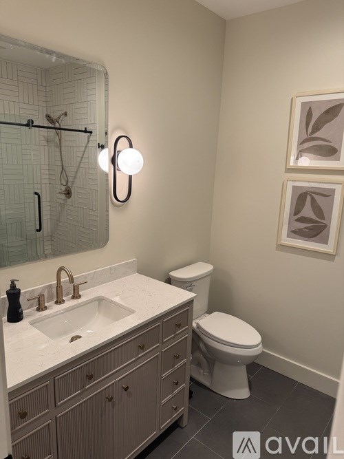 A bathroom with a sink, toilet, and mirror.