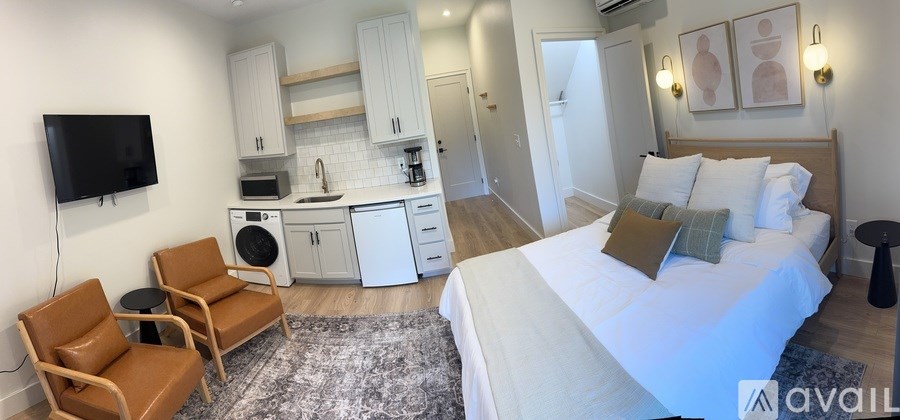 A bedroom with a bed, a chair, and a television.