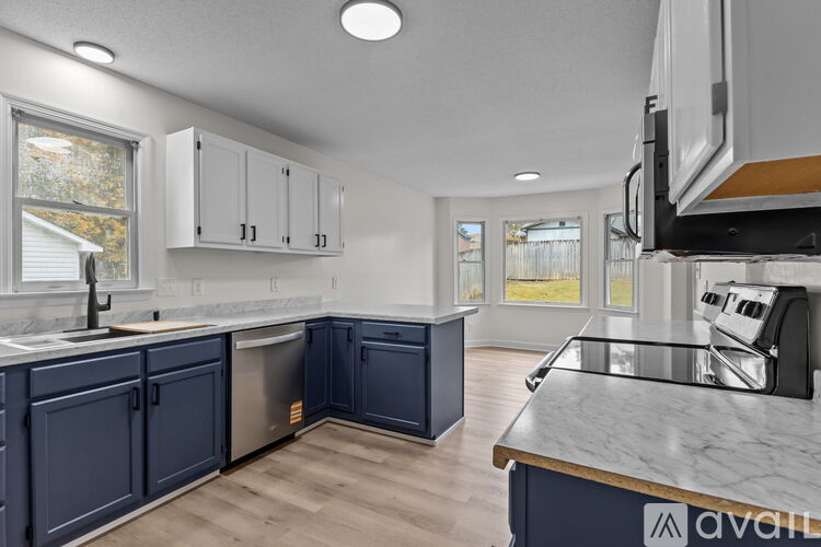 A kitchen with a blue island and wooden floors.