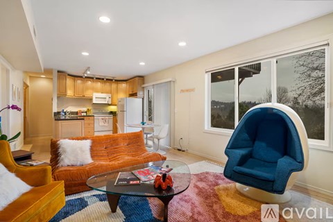 A living room with a blue chair and orange couch.