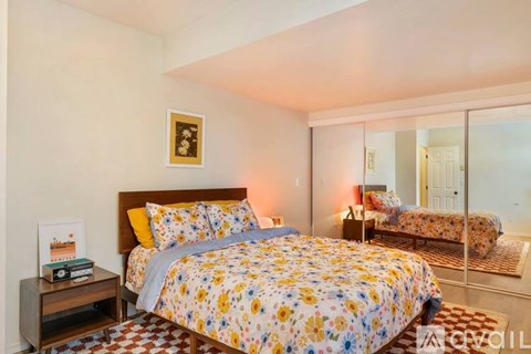A bedroom with a large bed and a mirror on the wall.
