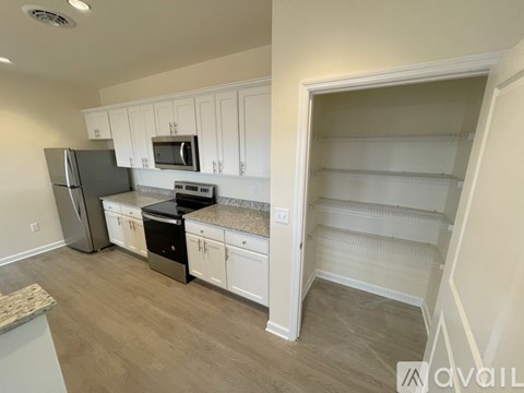 A kitchen with white cabinets and a refrigerator.