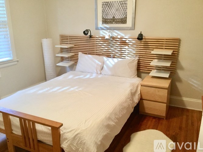 A bedroom with a bed, nightstand, and chair.