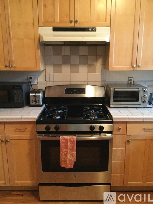 A kitchen with a stove, oven, microwave, and toaster.