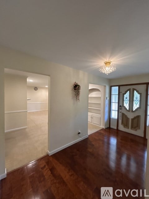 A room with wooden floors and a chandelier.