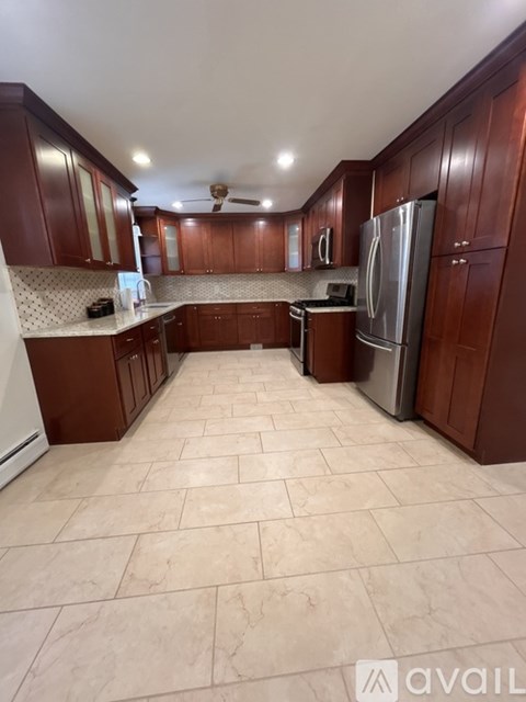 A kitchen with wooden cabinets and a tile floor.
