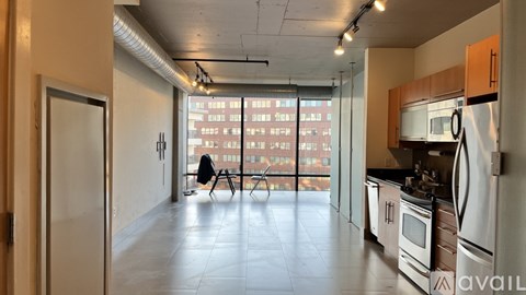 A kitchen with a refrigerator, microwave, and oven is available for rent.