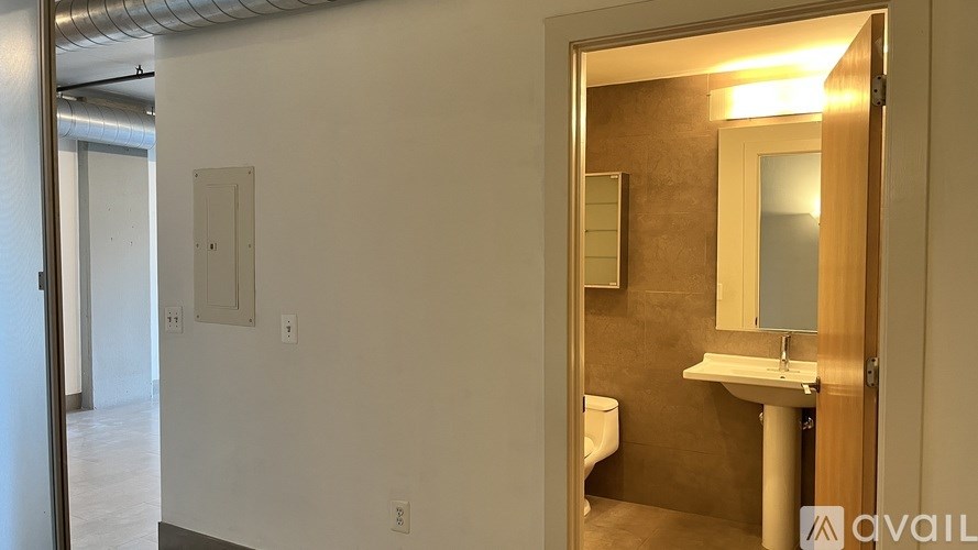 A bathroom with a toilet, sink and mirror.