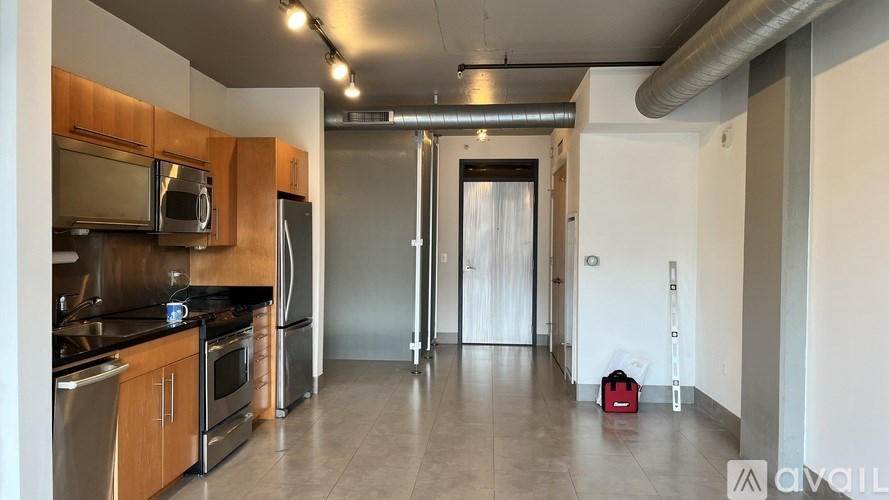 A kitchen with a refrigerator, sink, and microwave.
