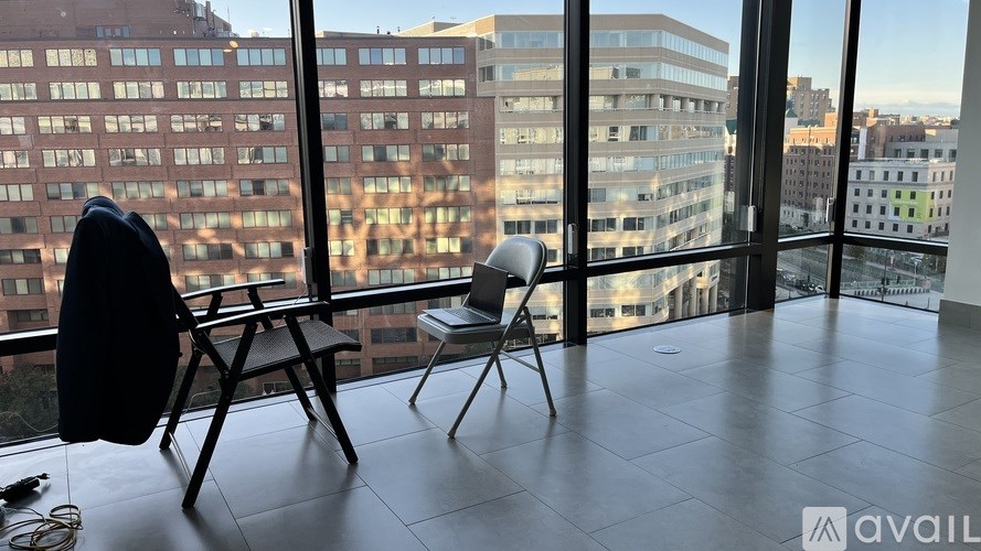A room with a chair and a table with a laptop on it.