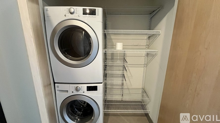 A stack of two front loading washing machines in a laundry room.