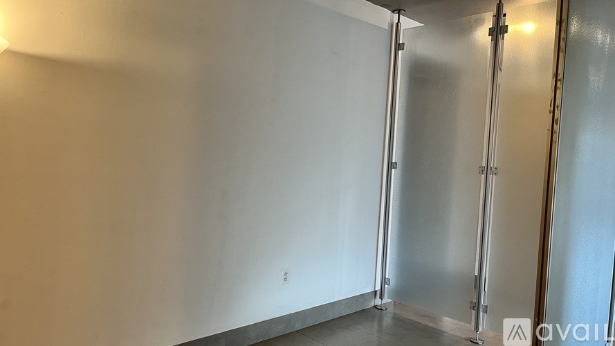 A room with a white wall and a metal door.