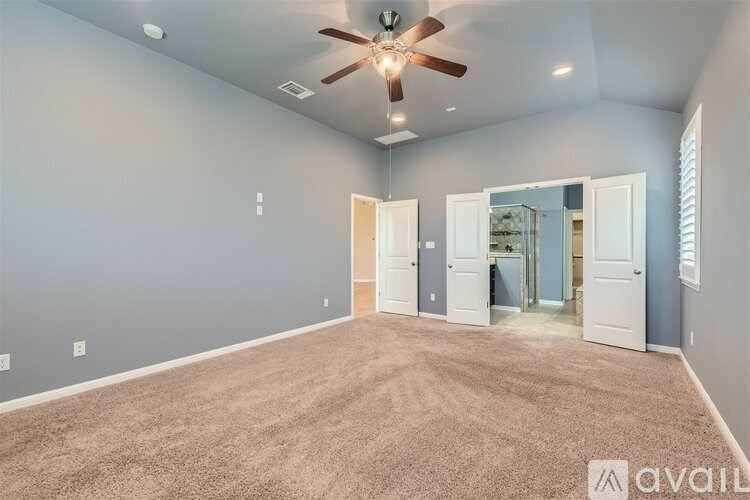 A room with a ceiling fan and carpeted floor.