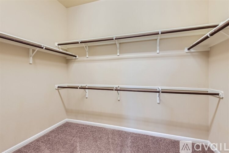 A room with a carpeted floor and two metal racks mounted on the wall.