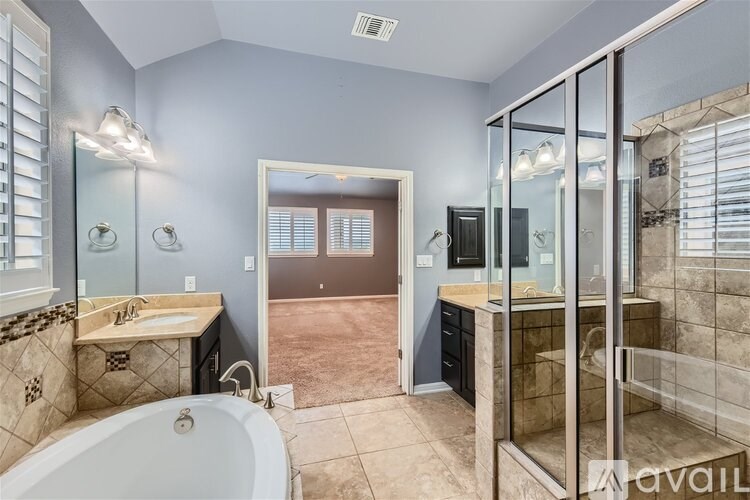 A bathroom with a tub, sink, and shower.