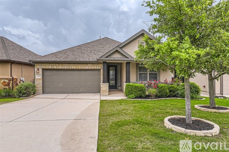 A house with a driveway and a tree in front.