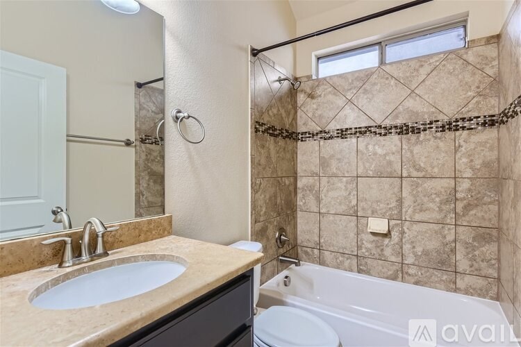 A bathroom with a sink, toilet, and bathtub.