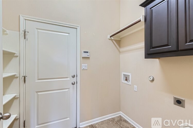 A white door is open to a hallway with a brown carpet.
