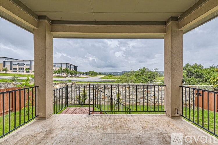 A balcony with a black railing and a view of a street and buildings.