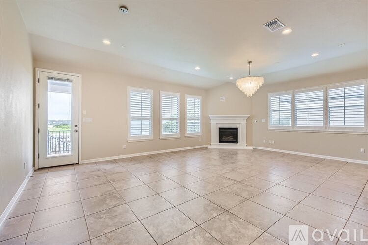 A spacious living room with a fireplace and large windows.