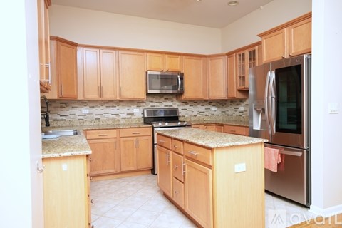 A kitchen with wooden cabinets and granite countertops.
