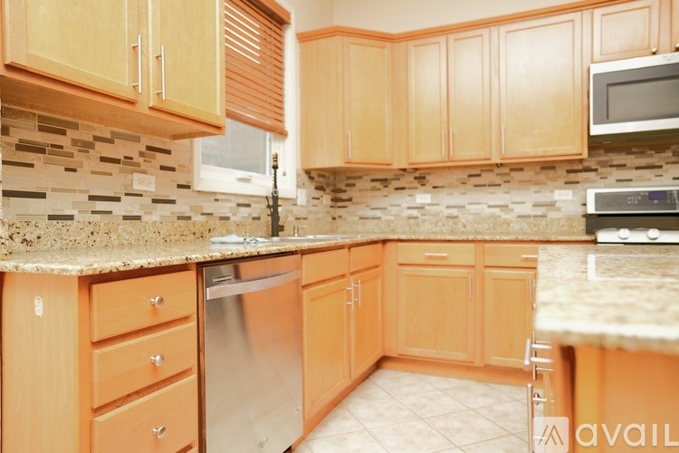 A kitchen with wooden cabinets and a tiled backsplash.