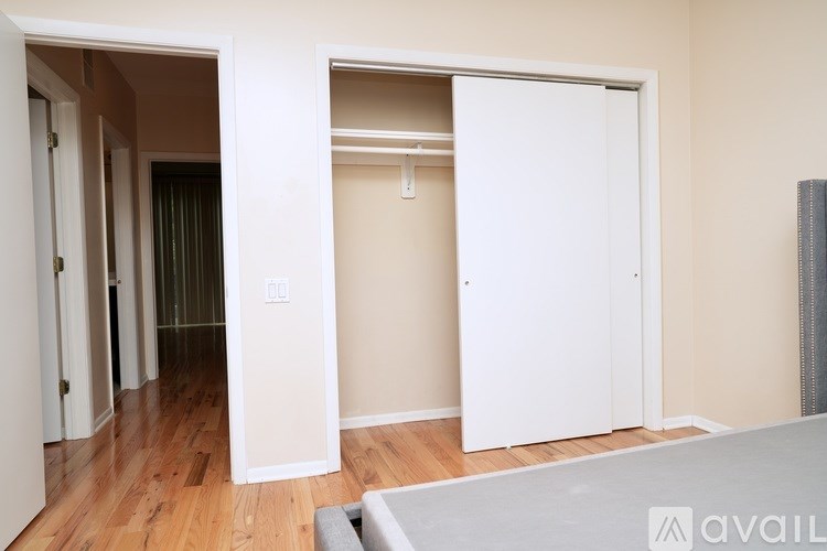 A room with a white door and a grey sofa.