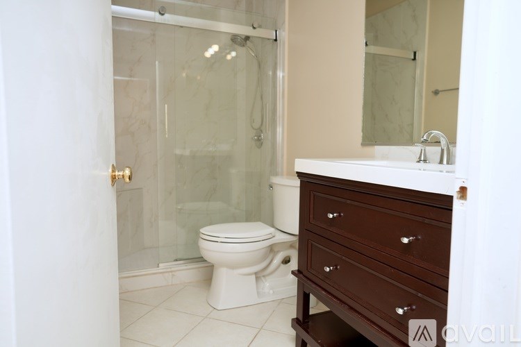 A bathroom with a toilet, sink, and shower.