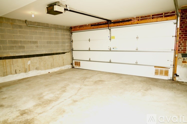 A garage with a white door and a brick wall.