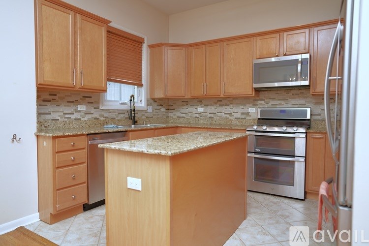A kitchen with wooden cabinets and a granite countertop.