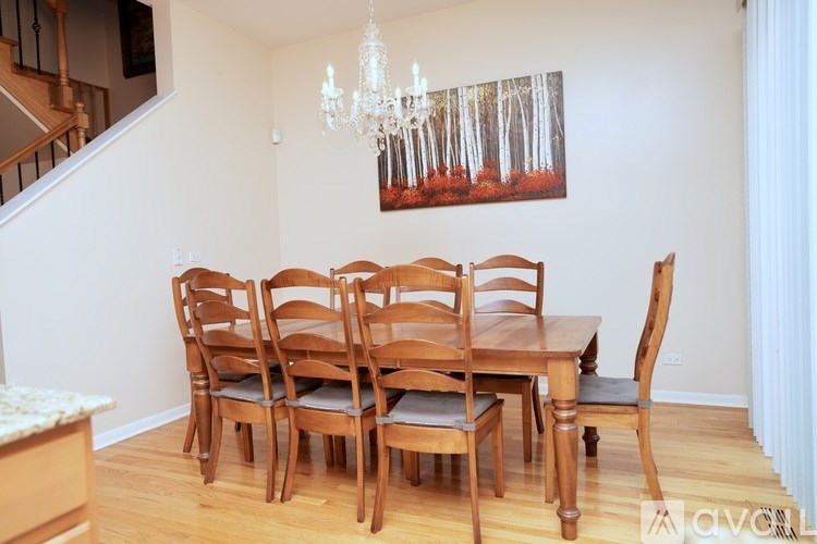 A wooden dining table with chairs and a chandelier in a room.