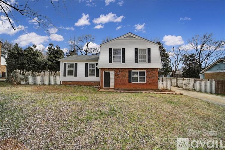 A two-story house with a white front and a brick section in the middle.