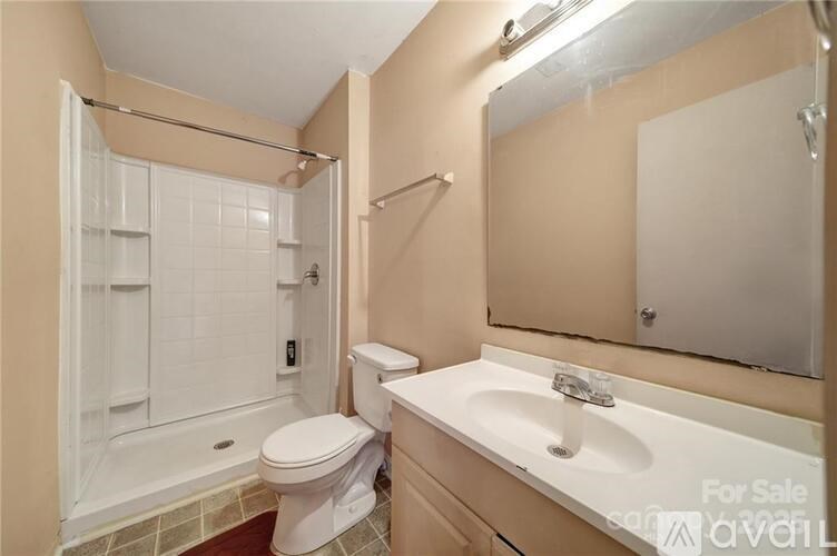 A bathroom with a toilet, sink, and shower.