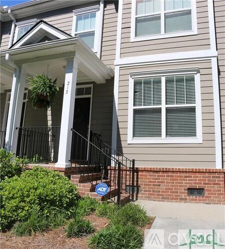 A house with a front porch and a sign that says "For Sale".