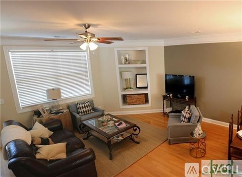 A living room with a brown leather couch and a glass coffee table.