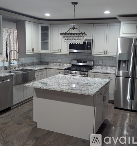 A kitchen with a granite countertop and stainless steel appliances.