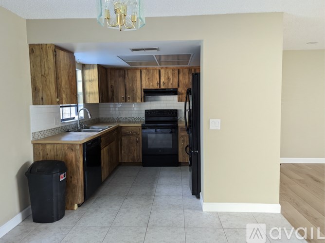 A kitchen with wooden cabinets and black appliances.