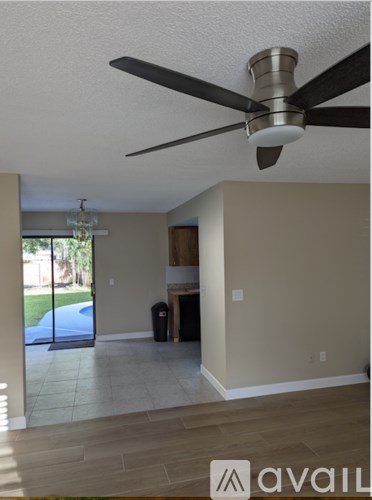 A room with a ceiling fan and a door leading outside.