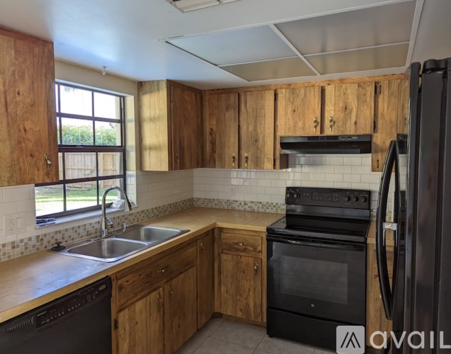 A kitchen with wooden cabinets and black appliances.