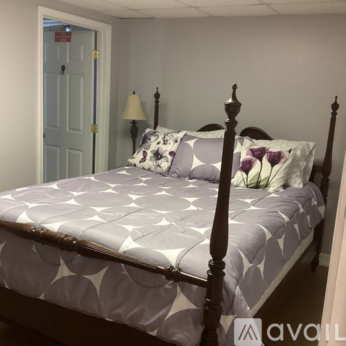 A bed with a white comforter and a wooden frame.