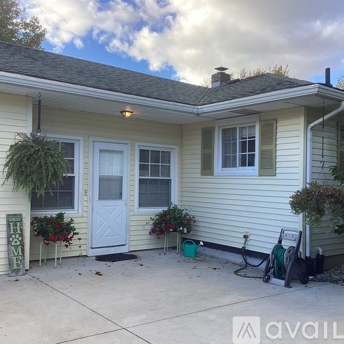 A house with a white door and windows with a sign that says home.