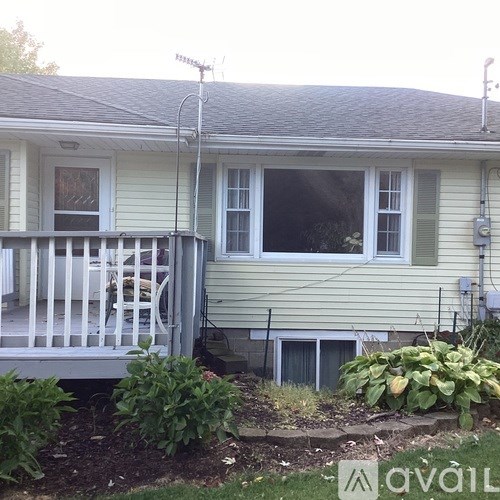 A house with a white porch and a window with a screen.