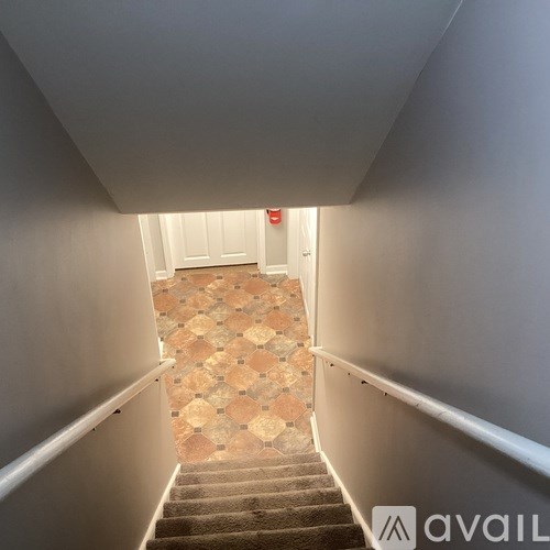 A staircase with a tiled floor and a carpeted stairway.