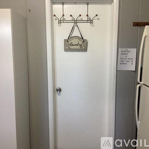 A white door with a sign that says "Laundry" hanging on it.