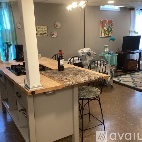 A kitchen with a marble countertop and a wooden island.