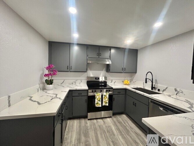 A kitchen with a marble countertop and stainless steel appliances.